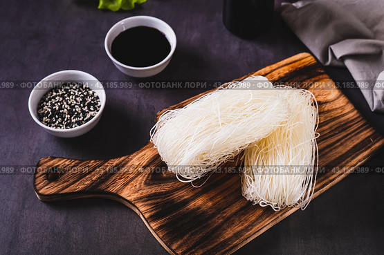 Two servings of funchose dry rice noodles on a board on the table. Стоковое фото, фотограф Елена Руй / Фотобанк Лори
