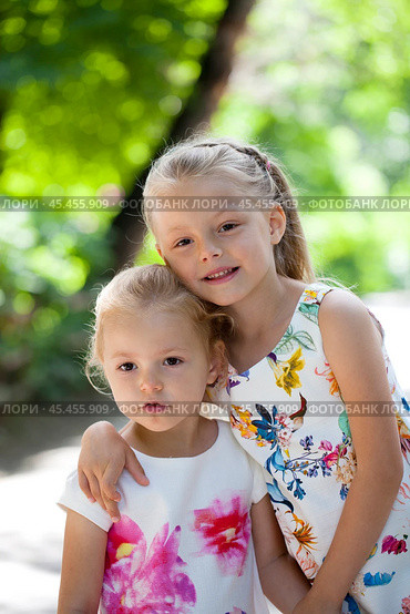 Two sisters family portrait on background of summer park. Стоковое фото, фотограф Андрей Аркуша / Фотобанк Лори