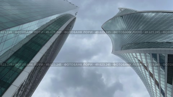 Two tall buildings of the Moscow City business district against a cloudy sky. Russia. Moscow. 12.06.25. Стоковое видео, видеограф Ярославский Максим / Фотобанк Лори