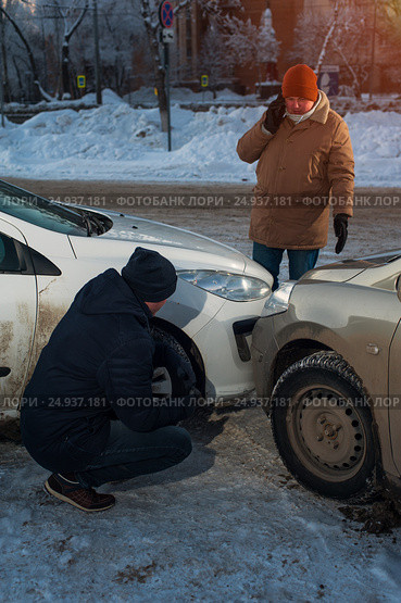 Two upset male drivers looking at cars after crash. Стоковое фото, фотограф Pavel Biryukov / Фотобанк Лори