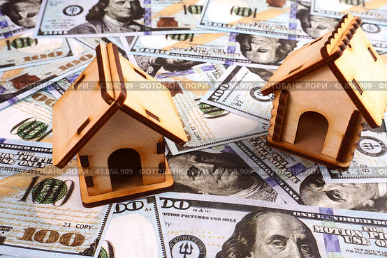 Two wooden houses on a background of hundred dollar bills. The concept of a mortgage. Стоковое фото, фотограф Ярославский Максим / Фотобанк Лори