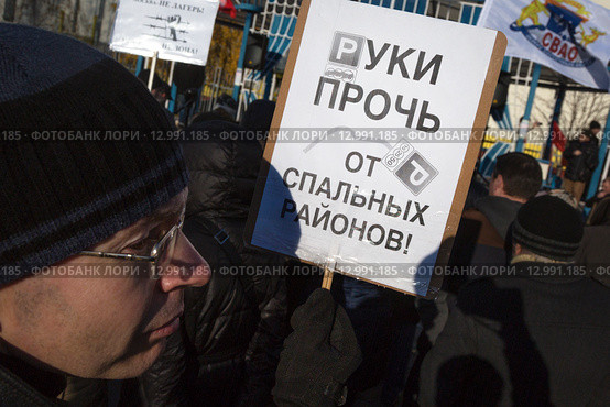 Участник митинга против расширения зоны платной парковки в спальные районы города Москвы держит плакат с надписью - "Руки прочь от спальных районов!" (2015 год). Редакционное фото, фотограф Николай Винокуров / Фотобанк Лори