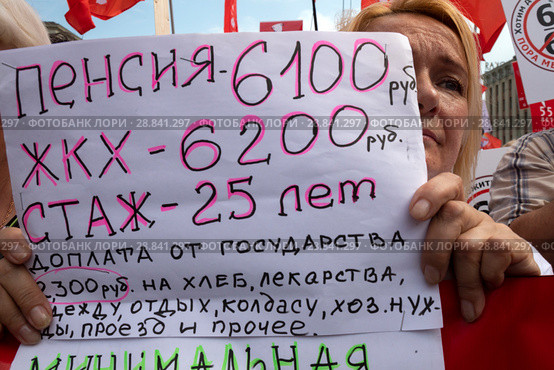 Участники митинга КПРФ против повышения пенсионного возраста на проспекте Сахарова в городе Москве держат плакаты с требованием оставить старый пенсионный возраст, Россия (2018 год). Редакционное фото, фотограф Николай Винокуров / Фотобанк Лори