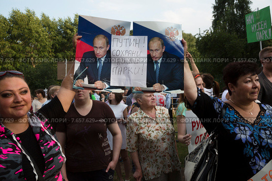 Участники санкционированного митинга против строительства храма в парке города Москвы держат плакаты с просьбой к Президенту РФ Владимиру Путину о защите парка "Торфянка", Россия (2015 год). Редакционное фото, фотограф Николай Винокуров / Фотобанк Лори