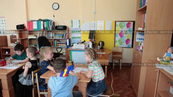 Учитель помогает детям на уроке с дошкольниками на подготовительных курсах к школе (2015 год). Редакционное видео, видеограф Кекяляйнен Андрей / Фотобанк Лори