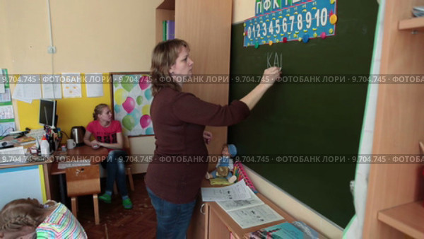 Учительница пишет слово канал на зеленой школьной доске (2015 год). Редакционное видео, видеограф Кекяляйнен Андрей / Фотобанк Лори