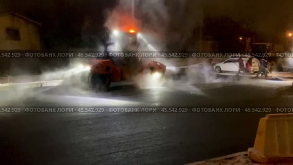 Укладка асфальта при помощи техники в тёмное время года зимой. Стоковое видео, видеограф Владимир Шипикин / Фотобанк Лори