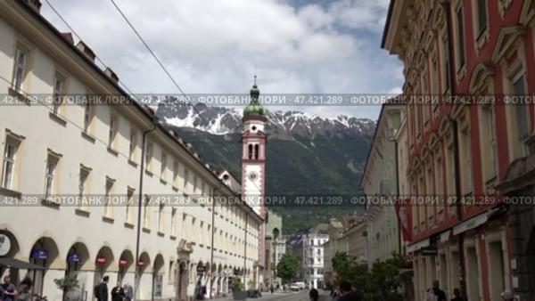 Улица города Инсбрук с видом на церковь и горы. Австрия. Май. Street of the city of Innsbruck with a view of the church and mountains. Austria. May. Редакционное видео, видеограф Горшков Александр / Фотобанк Лори