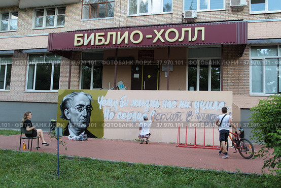 Улыбчивы уличный художник Сергей Юраков расписывает стену центральной библиотеки имени Ф.И. Тютчева в Балашихе (2022 год). Редакционное фото, фотограф Дмитрий Неумоин / Фотобанк Лори
