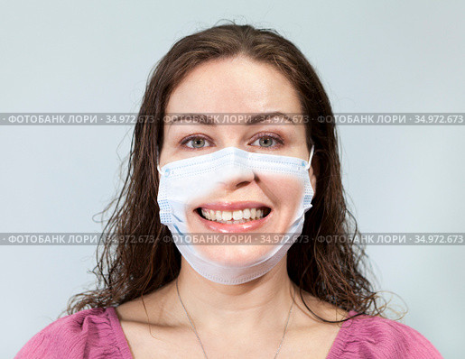 Uncertainty and embarrassment are on the face of an adult woman under medical mask with calm eyes. Supposition of real emotion while wearing mask. Стоковое фото, фотограф Кекяляйнен Андрей / Фотобанк Лори