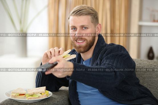 unemployed man sitting on the couch watching tv. Стоковое фото, агентство Ingram Publishing / Фотобанк Лори