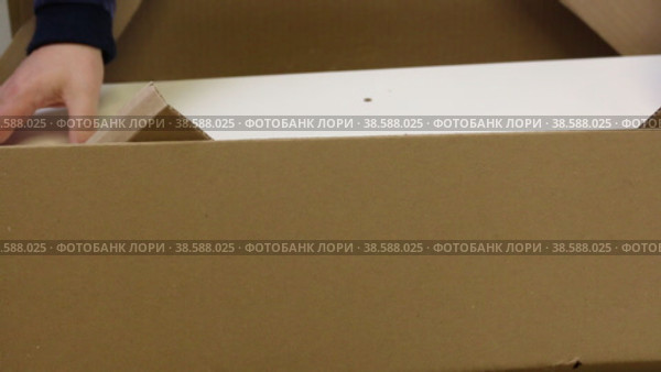 Unpacking the modular rack. The man opens the package and examines the wooden elements. Close-up. Стоковое видео, видеограф Vadzim Yakubovich / Фотобанк Лори