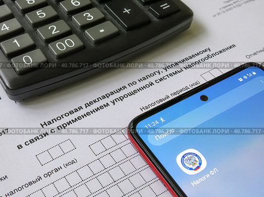 Упрощенная система налогообложения. Налоговая декларация, электронное приложение "Налоги" и калькулятор. Редакционное фото, фотограф Татьяна Т / Фотобанк Лори