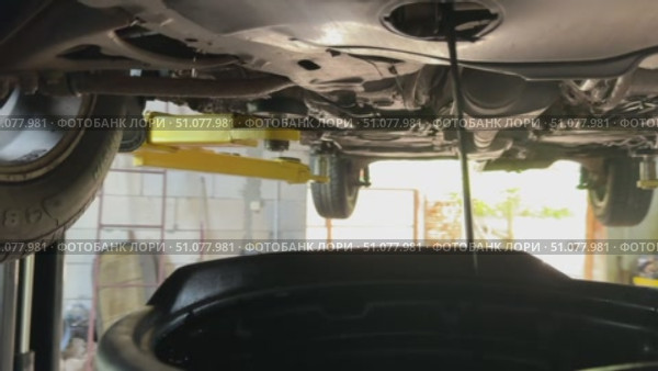 Used car oil draining into a pan. Engine oil change in a car. Car on a lift. Стоковое видео, видеограф Vadzim Yakubovich / Фотобанк Лори