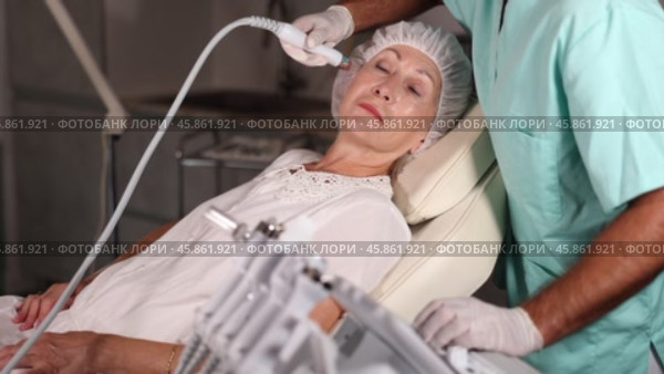 Using Hydrorgen Oxygen Hydrating, male physician enhances woman's features through tailored procedures. Стоковое видео, видеограф Яков Филимонов / Фотобанк Лори