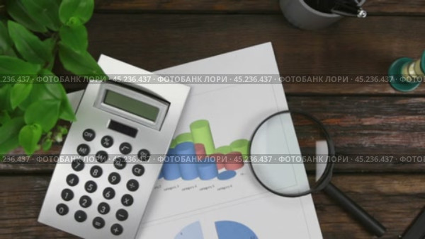 Увеличение. Рабочий стол, сосредоточьтесь на графике, калькуляторе и увеличительном стекле. Вид сверху. История бизнеса. Стоковое видео, видеограф Александр Собко / Фотобанк Лори