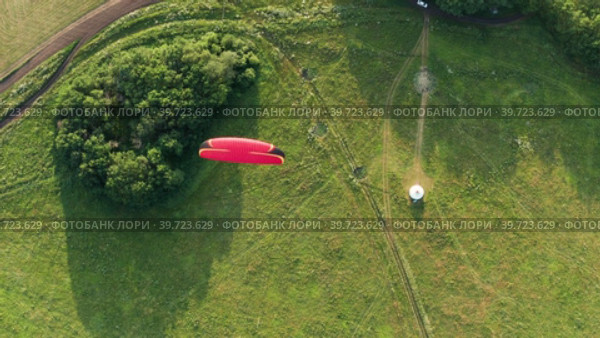 Южный Урал, мотопараплан, летящий над полем. Вид с воздуха. Southern Urals, a paramotor flying over the field. Aerial view. Стоковое видео, видеограф Евгений Романов / Фотобанк Лори