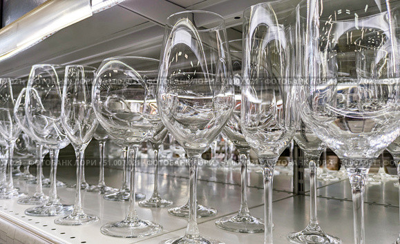Variety of clear glass stemware, including multiple styles of wine glasses, on store shelf. Suitable for concepts of glassware, wine tasting and home goods retail. Стоковое фото, фотограф Елена Никишина / Фотобанк Лори