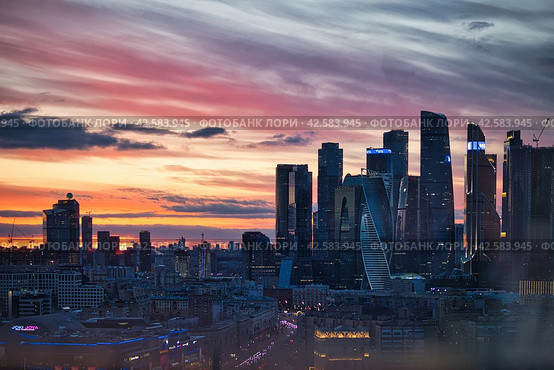Вечерний вид на Москву с высоты в районе делового центра Москва-Сити и Пресненского района. Красно-оранжевое небо с красивыми облаками. (2024 год). Редакционное фото, фотограф Сергей Никифоров-Гордеев / Фотобанк Лори