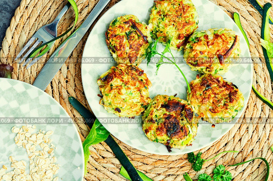 Vegan cutlets or fritter from zucchini, oatmeal and greens.. Diet zucchini cutlets. Стоковое фото, агентство Ingram Publishing / Фотобанк Лори