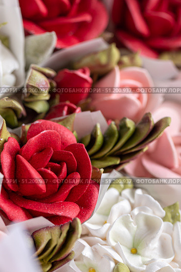 Vibrant home-made zephyr floristry featuring intricate red and pink floral designs, showcasing delicate textures and artistic craftsmanship in a visually appealing arrangement. Стоковое фото, фотограф Ирина Ручушкина / Фотобанк Лори