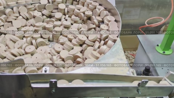 Vibratory device mechanism with numerous small round wooden discs, each with hole in center, used for automated feeding in manufacturing process. Стоковое видео, видеограф Елена Никишина / Фотобанк Лори