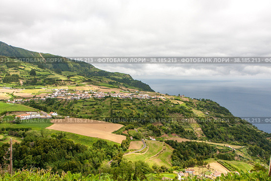 Вид на город с фермами в горах у моря, Сан-Мигель - Азорские острова. View of the city with farms in the mountains near the sea, Sao Miguel - Azores (2014 год). Стоковое фото, фотограф Марина Шабардина / Фотобанк Лори