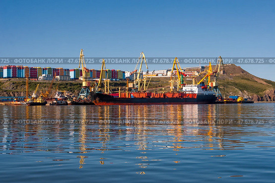 Вид на морской порт, расположенный на Крайнем Севере России в Арктике. Грузовое судно у причала. Большие портовые краны. Морские перевозки и стивидорные работы. Город Анадырь, Чукотский автономный округ (Чукотка), Дальний Восток России. Стоковое фото, фотограф Андрей Степанов / Фотобанк Лори