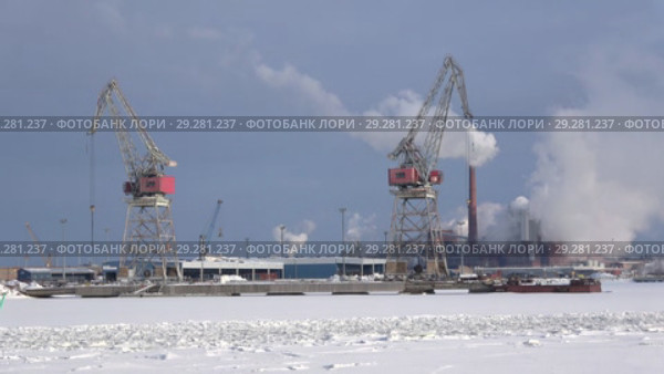 Вид на портовые краны и дымящий целлюлозно-бумажный комбинат "Sunila" морозным февральским днем. Котка, Финляндия (2018 год). Редакционное видео, видеограф Виктор Карасев / Фотобанк Лори