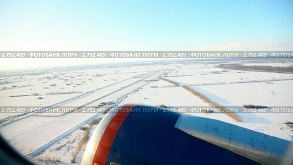 Вид на сибирский простор из иллюминатора реактивного самолета. Новая взлетная полоса новосибирского аэропорта Толмачево. Стоковое видео, видеограф Игорь Жоров / Фотобанк Лори