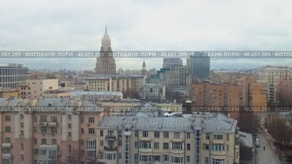 Вид на здание МИД России и старую Москву в пасмурную погоду.   Городской пейзаж Москвы с высоты. На переднем плане — жилые дома с серыми крышами, а вдали возвышается здание Министерства иностранных дел России — одна из сталинских высоток. Стоковое видео, видеограф Анна Чижова / Фотобанк Лори