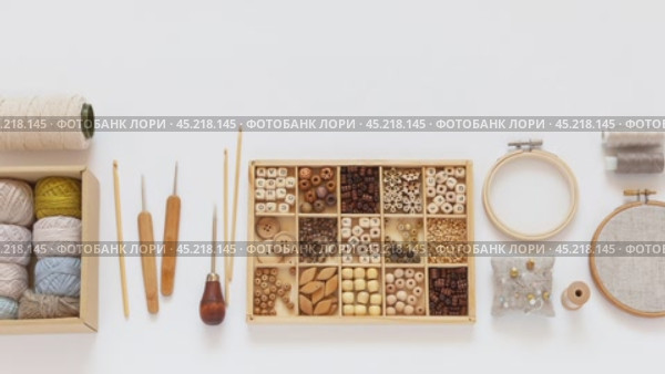 Video of natural materials for craft or needlework. Accessories for crochet and hand embroidery: hoops, set of cotton yarn, crochet hooks, box with wooden beads. Making handmade gifts. DIY concept. Стоковое видео, видеограф Виктория Катьянова / Фотобанк Лори