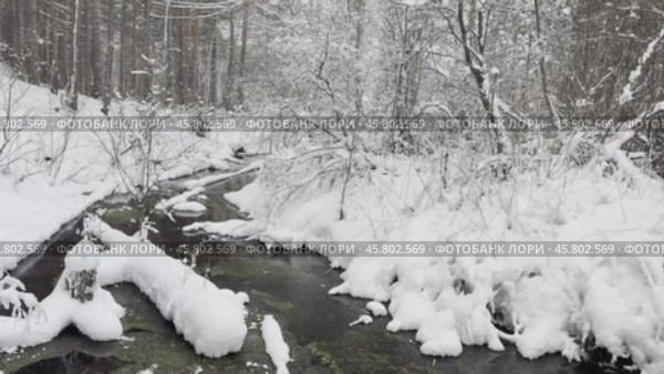 Video of winter landscape with non-freezing river Oda into which natural springs and sources flow. Snow-covered hilly river bank and forest. Winter travels and walks in nature. Стоковое видео, видеограф Виктория Катьянова / Фотобанк Лори