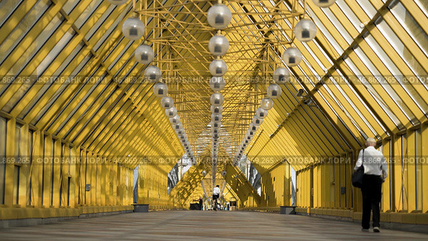 View inside of Andreyevskiy bridge with bright yellow metal beams and hanging lanterns. Стоковое фото, фотограф David Kashakhi / Фотобанк Лори