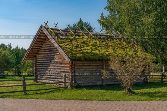 View of an ancient log outbuilding on the territory of the Pushkin village in Bugrovo of the Pushkin Museum-Reserve on a sunny summer day, Pushkinskiye Gory, Pskov region, Russia. Редакционное фото, фотограф Ula Ulachka / Фотобанк Лори