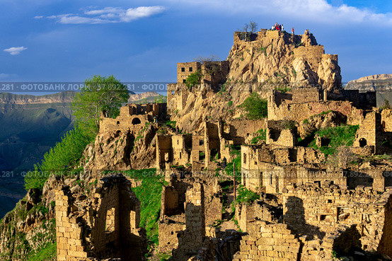 View of the abandoned village of Gamsutl on top of a mountain in Dagestan, with tourists among the ruins (2022 год). Стоковое фото, фотограф Евгений Харитонов / Фотобанк Лори