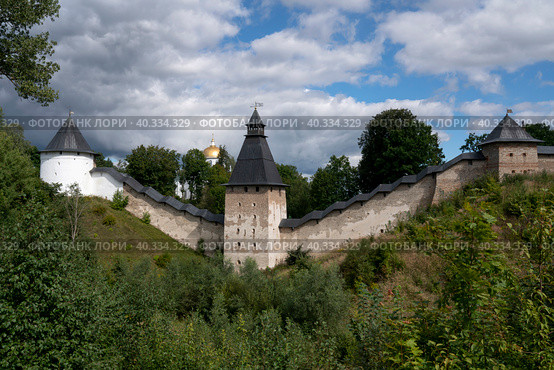 View of the wall of the Holy Dormition Pskov-Pechersk Monastery, the Tower of the Upper Lattices, Tailovskaya tower and Tararygin Tower on a sunny summer day, Pechory, Pskov region, Russia. Стоковое фото, фотограф Ula Ulachka / Фотобанк Лори