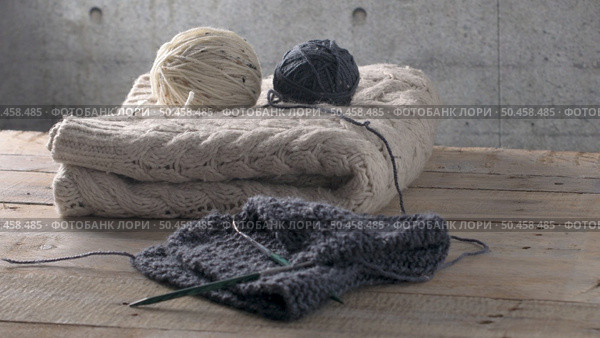 Vintage Knitting needles and yarn on wooden background/natural wool knitting background. Стоковое фото, агентство Ingram Publishing / Фотобанк Лори