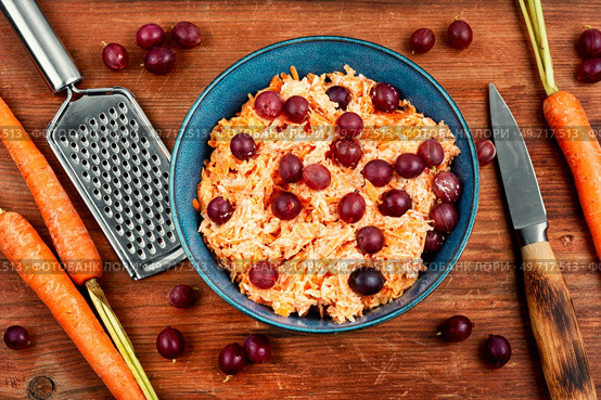 Vitamin salad of grated carrots and gooseberries on wooden background.. Grated carrots salad. Стоковое фото, агентство Ingram Publishing / Фотобанк Лори