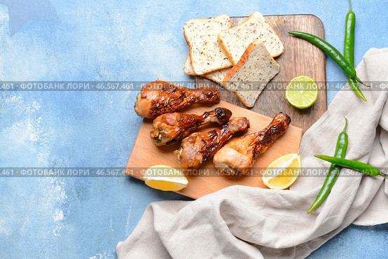 Вкусные куриные голени с хлебом на цветном фоне. Стоковое фото, фотограф Pixel_shot / Фотобанк Лори