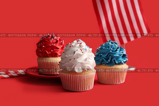 Вкусные патриотичные кексы с флагом США на красном фоне. День независимости Америки. Стоковое фото, фотограф Pixel_shot / Фотобанк Лори