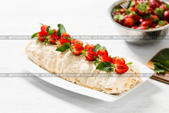 Вкусный рулет из безе с клубникой на столе. Стоковое фото, фотограф Pixel_shot / Фотобанк Лори