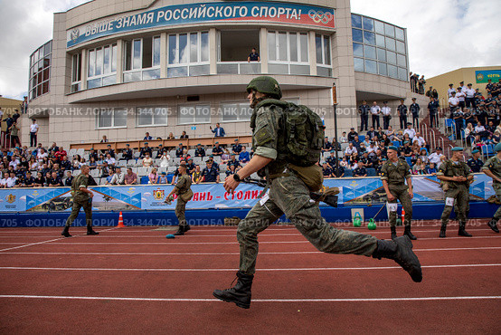 Военнослужащий ВДВ бежит с оружием и в полной экипировке в эстафете на стадионе "Спартак" в городе Рязани в День ВДВ, Россия (2020 год). Редакционное фото, фотограф Николай Винокуров / Фотобанк Лори
