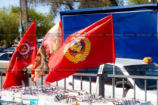 VOLGOGRAD, RUSSIA - April 17, 2021: Sale of Soviet and Russian red flags on the city street in summer. Редакционное фото, фотограф Владимир Арсентьев / Фотобанк Лори