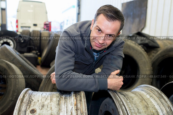 vulcanizing worker posing on a tire rim. Стоковое фото, агентство Ingram Publishing / Фотобанк Лори