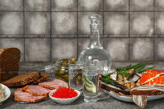 Выстрелы с холодной водкой и закуски на столе. Стоковое фото, фотограф Pixel_shot / Фотобанк Лори