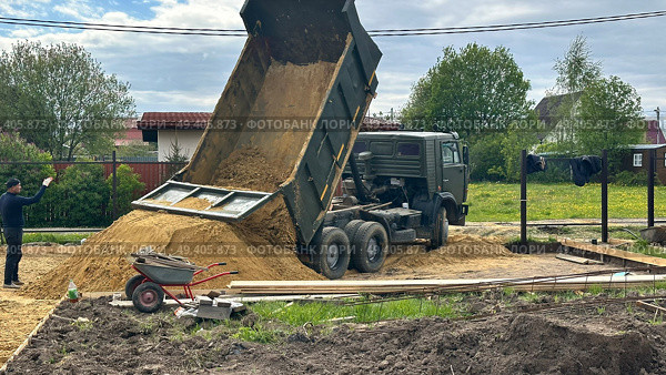 Высыпание песка самосвалом на строительной площадке. Редакционное фото, фотограф Антон Моргунов / Фотобанк Лори