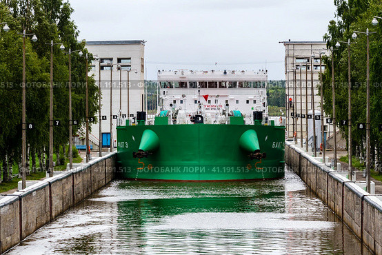Vytegra, Russia - August 16, 2015: Cargo ship entered the White Sea-Baltic Canal Gateway. It connects the White Sea, in the Arctic Ocean, with Lake Onega, which is further connected to the Baltic Sea. Редакционное фото, фотограф VittoriaChe / Фотобанк Лори