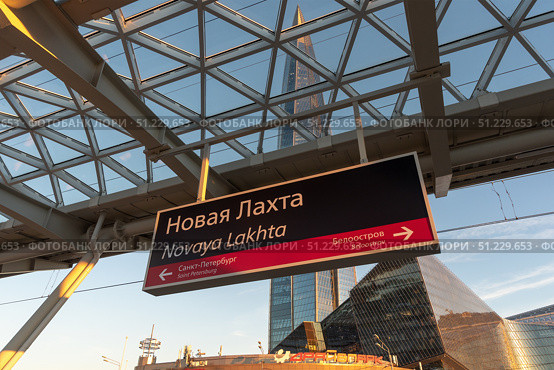 Вывеска с наименованием. Железнодорожный остановочный пункт Новая Лахта в Приморском районе города Санкт-Петербурга. Комплекс зданий «Лахта Центра» на заднем плане. Редакционное фото, фотограф Румянцева Наталия / Фотобанк Лори