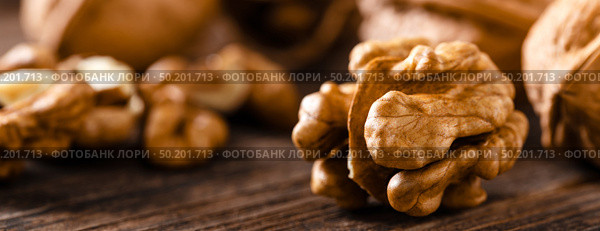 Walnuts. Kernels and whole nuts on wooden rustic table closeup, banner. Стоковое фото, агентство Ingram Publishing / Фотобанк Лори
